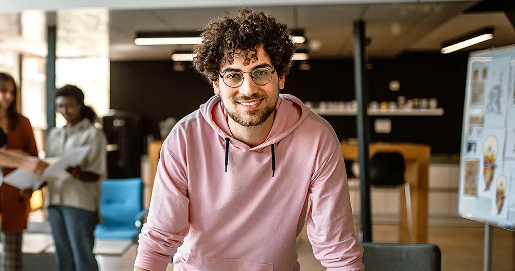 Jonge lachende zakenman in creatief kantoor
