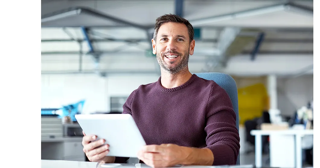 Vriendelijk lachende man met tablet in de hand